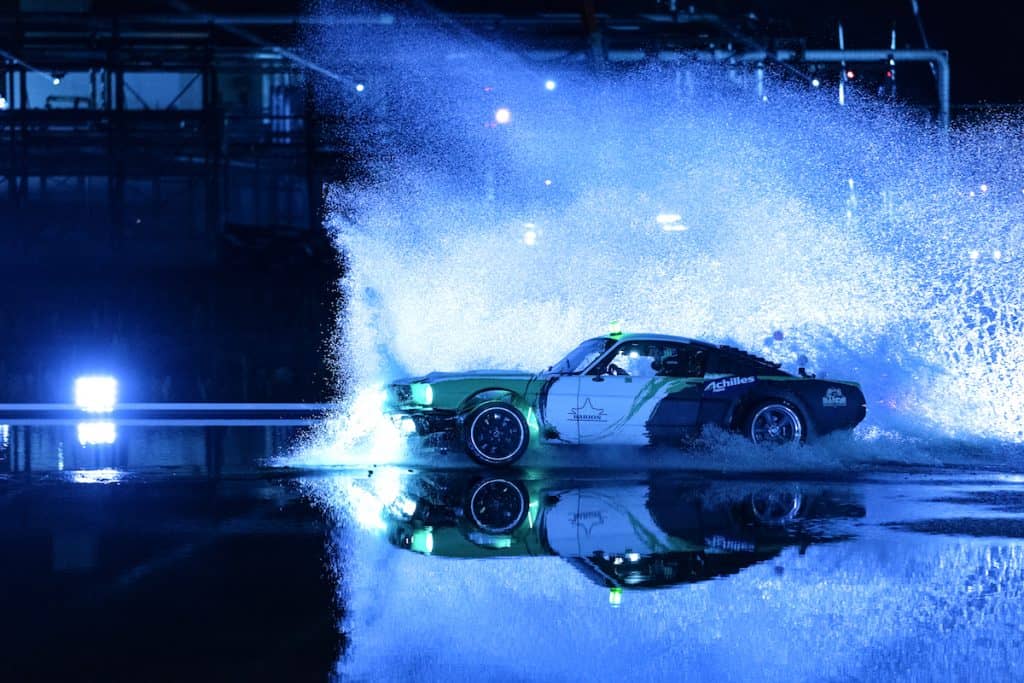 drift car drifting around a tire stack 4k night time